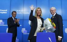 Newly elected European Council President Donald Tusk (L) of Poland applauds during a news conference with outgoing European Council President Herman Van Rompuy (R) and newly elected European High Representative for Foreign Affairs Federica Mogherini (C) of Italy during an EU summit in Brussels