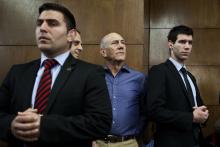 Former Israeli Prime Minister Ehud Olmert (2nd R) waits to hear his verdict at the Tel Aviv District Court