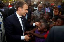 French President Emmanuel Macron greets children as he arrives to visit a school in Ouagadougou, Burkina Faso, November 28, 2017. PHOTO BY REUTERS/Philippe Wojazer