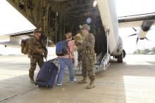 Marines and sailors with Special-Purpose Marine Air-Ground Task Force Crisis Response help U.S. citizens into a Marine Corps KC-130J Hercules airplane during an evacuation of personnel from the U.S. Embassy, in this handout photo