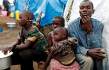 Mave Grace (L), 11, who had part of her arm chopped off by militiamen when they attacked the village of Tchee, sits with her sister Francine Imani, aged six, her other sister, Racahele-Ngabausi, aged two and her father, Nyine Richard, in an Internally Displaced Camp in Bunia, Ituri province, eastern Democratic Republic of Congo, April 12, 2018. PHOTO BY REUTERS/Goran Tomasevic