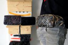 Visual artist Adeyemi Emmanuel samples a fanny pack he designed using pieces of wooden frames in his art studio in Lagos, Nigeria, February 14, 2020. PHOTO BY REUTERS/Temilade Adelaja