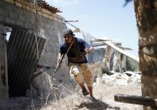 A fighter of Libyan forces allied with the U.N.-backed government runs for cover during a battle with Islamic State fighters in Sirte, Libya, July 31, 2016. PHOTO BY REUTERS/Goran Tomasevic