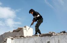 A fighter of Libyan forces stands atop the ruins of a house as the forces secure the last few buildings where Islamic State militants had been making a final stand, in Ghiza Bahriya district in Sirte, Libya December 6, 2016. PHOTO BY REUTERS/Hani Amara