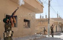 Kurdish fighters from the People's Protection Units (YPG) fire rifles at a drone operated by Islamic State militants in Raqqa, Syria, June 16, 2017. PHOTO BY REUTERS/Goran Tomasevic