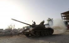 Fighters from the Benghazi Shura Council, which includes former rebels and militants from al Qaeda-linked Ansar al-Sharia, gesture on top of a tank next to the camp of the special forces in Benghazi 