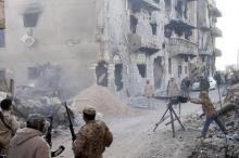 Members of the Libyan pro-government forces, backed by the locals, with weapons are seen during clashes in the streets with Shura Council of Libyan Revolutionaries, an alliance of former anti-Gaddafi rebels who have joined forces with Islamist group Ansar al-Sharia, in Benghazi, April 1, 2015. PHOTO BY REUTERS/Stringer