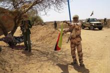 A fighter with the Tuareg separatist group MNLA (National Movement for the Liberation of Azawad) brandishes a separatist flag for the region they call Azawad outside the local regional assembly, where members of the rebel group met with the Malian army, the U.N. mission in Mali and French army officers, in Kidal