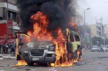 Smoke rises as protesters, supporters of ousted President Mohamed Mursi, burn the car of independent television channel Al-Tahrir TV, during clashes with police in al-Haram street, south of Cairo