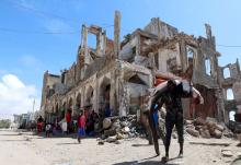 A fisherman carries his catch in front of buildings, destroyed during a war, in Hamarweyne district near a fishing port in Mogadishu, Somalia, September 14, 2018. PHOTO BY REUTERS/Feisal Omar