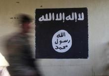 A member of the Iraqi rapid response forces walks past a wall painted with the black flag commonly used by Islamic State militants, at a hospital damaged by clashes during a battle between Iraqi forces and Islamic State militants in the Wahda district of eastern Mosul, Iraq, January 8, 2017. PHOTO BY REUTERS/Alaa Al-Marjani