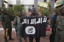 Malian security officials show a jihadist flag they said belonged to attackers in front of the Radisson hotel in Bamako, Mali, November 20, 2015. PHOTO BY REUTERS/Joe Penney