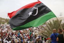 People hold a Libyan flag as they demonstrate in support of Khalifa Haftar's "Operation Dignity", a campaign against Islamists, at Martyrs' Square in Tripoli, May 23, 2014. PHOTO BY REUTERS/Ahmed Jadallah