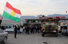 A man waves a Kurdistan flag as a Turkish military truck escorts a convoy of peshmerga vehicles at Habur border gate, which separates Turkey from Iraq, near the town of Silopi in southeastern Turkey, October 29, 2014. PHOTO BY REUTERS/Kadir Baris