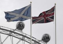 The British Union Flag (R) and a Scottish Saltire flag fly above the Scottish Office in Whitehall, with the London Eye wheel seen behind, in London, Britain, March 14, 2017. PHOTO BY REUTERS/Toby Melville