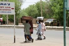 People flee with their belongings in Maiduguri in Borno State, Nigeria May 14, 2015. At least six civilians and six members of a youth vigilante group were killed in an attack by Boko Haram militants on Nigeria's northeastern city Maiduguri, two military sources said on Thursday. PHOTO BY REUTERS/Stringer 