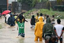 Residents wade through a flooded road in the aftermath of Cyclone Kenneth in Pemba, Mozambique, April 28, 2019. PHOTO BY REUTERS/Mike Hutchings