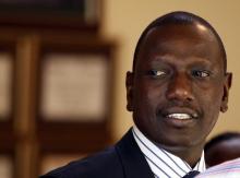 Former Kenyan Cabinet Minister William Ruto stands inside his house after hearing the news from the International Criminal Court