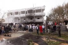 People stand among debris outside the French embassy after the building was attacked, in Tripoli, April 23, 2013. PHOTO BY REUTERS/Ismail Zitouny