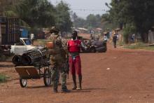 A French peacekeeping soldier searches a man for weapons in the district of Miskine of the capital Bangui 