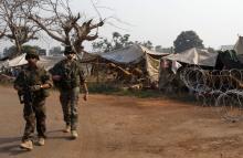 French soldiers from the peacekeeping forces walk near a camp for displaced people at M'Poko international airport in Bangui