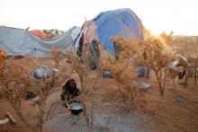 A Somali girl prepares food outside a makeshift shelter in an Internally displaced camp in the northern Somali town of Dollow, Somalia, February 26, 2018. PHOTO BY REUTERS/Baz Ratner