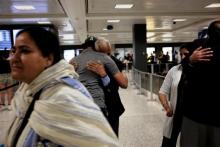 International passengers embrace family members as they arrive at Washington Dulles International Airport after the Trump administration's travel ban was allowed back into effect pending further judicial review, in Dulles, Virginia, U.S., June 29, 2017. PHOTO BY REUTERS/James Lawler Duggan