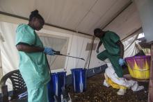 A health worker removes his protective suit as he emerges from an isolation area at the Medecins sans Frontieres Ebola treatment centre in Kailahun