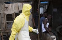 A health worker in protective equipment carries a sample taken from the body of someone who is suspected to have died from Ebola virus, near Rokupa Hospital, Freetown, October 6, 2014. PHOTO BY REUTERS/Christopher Black