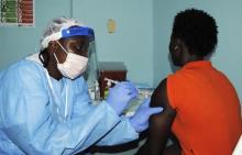 A health worker injects a woman with an Ebola vaccine in a file photo. PHOTO BY REUTERS/James Giahyue