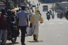 A health worker with disinfectant spray walks down a street outside the government hospital in Kenema, July 10, 2014. PHOTO BY REUTERS/Tommy Trenchard