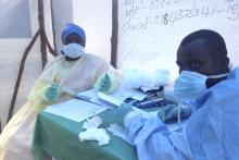 Government health workers are seen during the administration of blood tests for the Ebola virus in Kenema, Sierra Leone