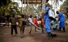 Children come forward to get their feet disinfected after a Red Cross worker explained that they are spraying bleach, and not spraying the village with the Ebola virus, in Forecariah, January 30, 2015. PHOTO BY REUTERS/Misha Hussain