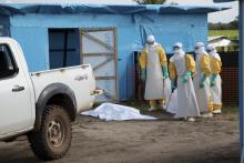 Health workers, wearing head-to-toe protective gear, prepare for work, outside an isolation unit in Foya District, Lofa County, Liberia