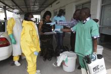 A health worker sprays a colleague with disinfectant during a training session for Congolese health workers to deal with Ebola virus in Kinshasa October 21, 2014. PHOTO BY REUTERS/Media Coulibaly