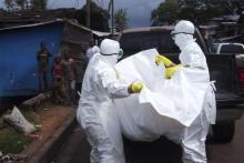 Health workers remove the body of a man believed to have died from the Ebola virus at a street in Monrovia, Liberia, October 27, 2014. PHOTO BY REUTERS/James Giahyue