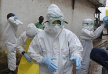 Health workers wearing protective clothing prepare to carry an abandoned dead body presenting with Ebola symptoms at Duwala market in Monrovia, August 17, 2014. PHOTO BY REUTERS/2Tango