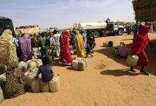 Internally displaced persons (IDPs) wait to get water at the Al-Abassi camp for IDPs in Mellit town, North Darfur