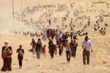 Displaced people from the minority Yazidi sect, fleeing violence from forces loyal to the Islamic State in Sinjar town, walk towards the Syrian border, on the outskirts of Sinjar mountain, near the Syrian border town of Elierbeh of Al-Hasakah Governorate, August 10, 2014. PHOTO BY REUTERS/Rodi Said