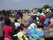 People displaced from fighting between the South Sudanese army and rebels, wait for boats to cross the Nile River, in Bor town, around 180 km (112 miles), northwest from the capital of Juba