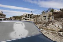 An image of Syria's President Bashar al-Assad is seen on a car parked in front of damaged buildings in the town of Rabiya, after pro-government forces recaptured the rebel-held town in coastal Latakia province, Syria January 27, 2016. PHOTO BY REUTERS/Omar Sanadiki