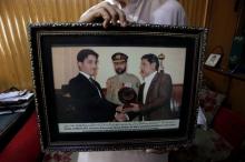 An image held by a colleague shows Pakistani journalist Zafarullah Achakzai (L), receiving a young journalist award from former Baluchistan Governor Nawab Zulfiqar Ali Magsi during a ceremony dated March 23, 2011, after his arrest in Quetta, Pakistan June 30, 2017. PHOTO BY REUTERS/Naseer Ahmed