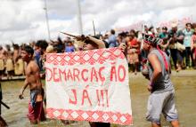 An indigenous man holds a sign reading "Demarcation Now" at the entrance of Justice Ministry during a protest to defend indigenous land and cultural rights, that according to protesters, are threatened by the right-wing government of Brazil's President Jair Bolsonaro, in Brasilia, Brazil, April 26, 2019. PHOTO BY REUTERS/Nacho Doce