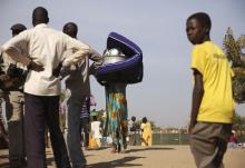 An internally displaced woman (C) carries her belongings inside a United Nations Missions in Sudan (UNMIS) compound in Juba