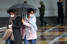 Iranian women wear protective masks to prevent contracting coronavirus, as they walk in the street in Tehran, Iran, February 25, 2020. PHOTO BY REUTERS/WANA (West Asia News Agency)/Nazanin Tabatabaee 