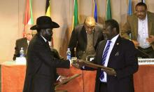 South Sudan's President Salva Kiir (front L) and South Sudan's rebel commander Riek Machar exchange documents after signing a ceasefire agreement during the Inter Governmental Authority on Development (IGAD) Summit on the case of South Sudan in Ethiopia's capital Addis Ababa, Feburary 1, 2015. PHOTO BY REUTERS/Tiksa Negeri