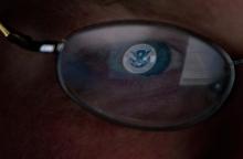 The logo of the U.S. Department of Homeland Security is reflected in the spectacles of an analyst working in a watch and warning center of a cyber security defense lab at the Idaho National Laboratory in Idaho Falls, Idaho, September 29, 2011. PHOTO BY REUTERS/Jim Urquhart