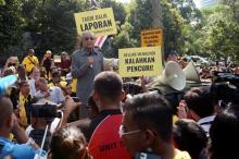 Malaysia's opposition coalition prime ministerial candidate Mahathir Mohamad speaks against a controversial proposal to redraw electoral boundaries outside near the Parliament House in Kuala Lumpur, Malaysia March 28, 2018. The sign (front R) reads: "Go out and vote, defeat the thief". PHOTO BY REUTERS/Stringer