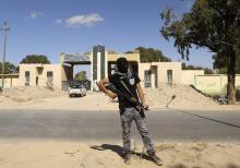 A militia stands guard in front of the entrance to the February 17 militia camp after Libyan irregular forces clashed with them in the eastern city of Benghazi