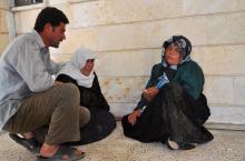 A man comforts a woman after activists said people were killed by the Islamic State in Iraq and the Levant (ISIL), in a village near Ras al-Ain city in Hasakah province